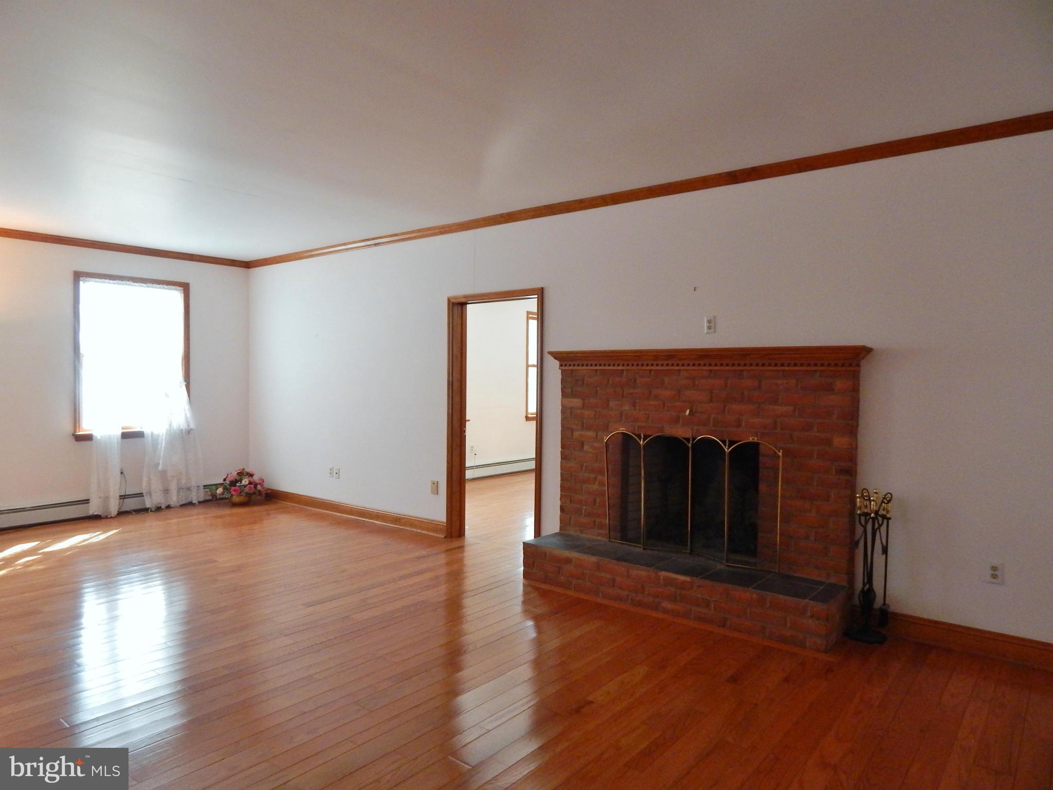 3964 Street Road Street, MD 21154 - Photo 18 of 29 a view of empty room with wooden floor and fireplace