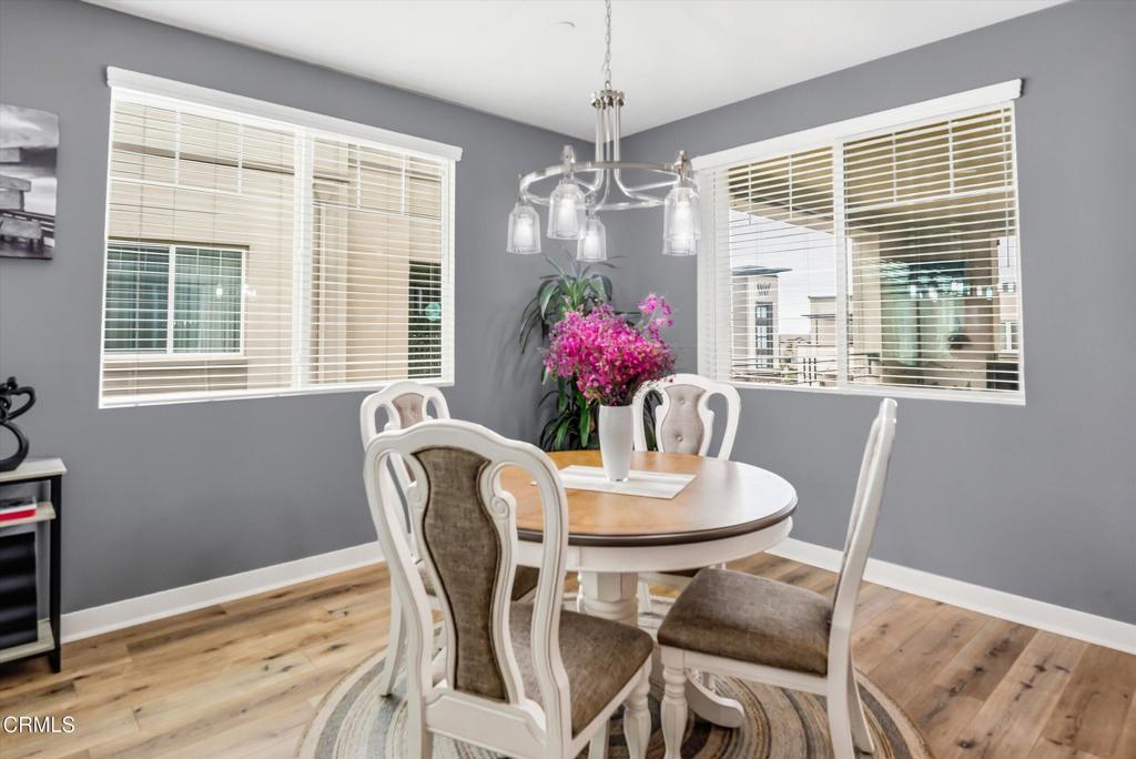 2820 Wagon Wheel Road, Unit 403 Oxnard, CA 93036 - Photo 16 of 35 a dining room with furniture a chandelier and wooden floor