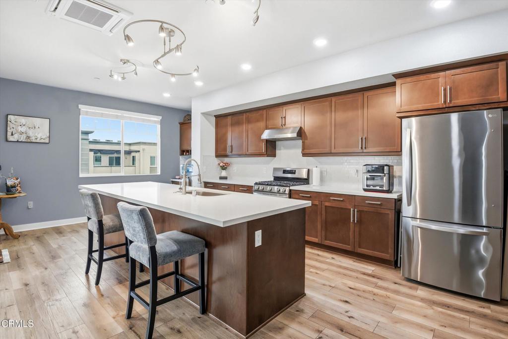 2820 Wagon Wheel Road, Unit 403 Oxnard, CA 93036 - Photo 19 of 35 a kitchen with stainless steel appliances granite countertop a sink a stove a refrigerator cabinets and a dining table