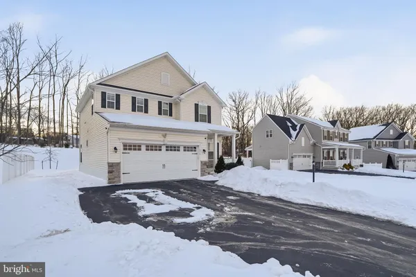 a view of a white house with a yard covered in snow