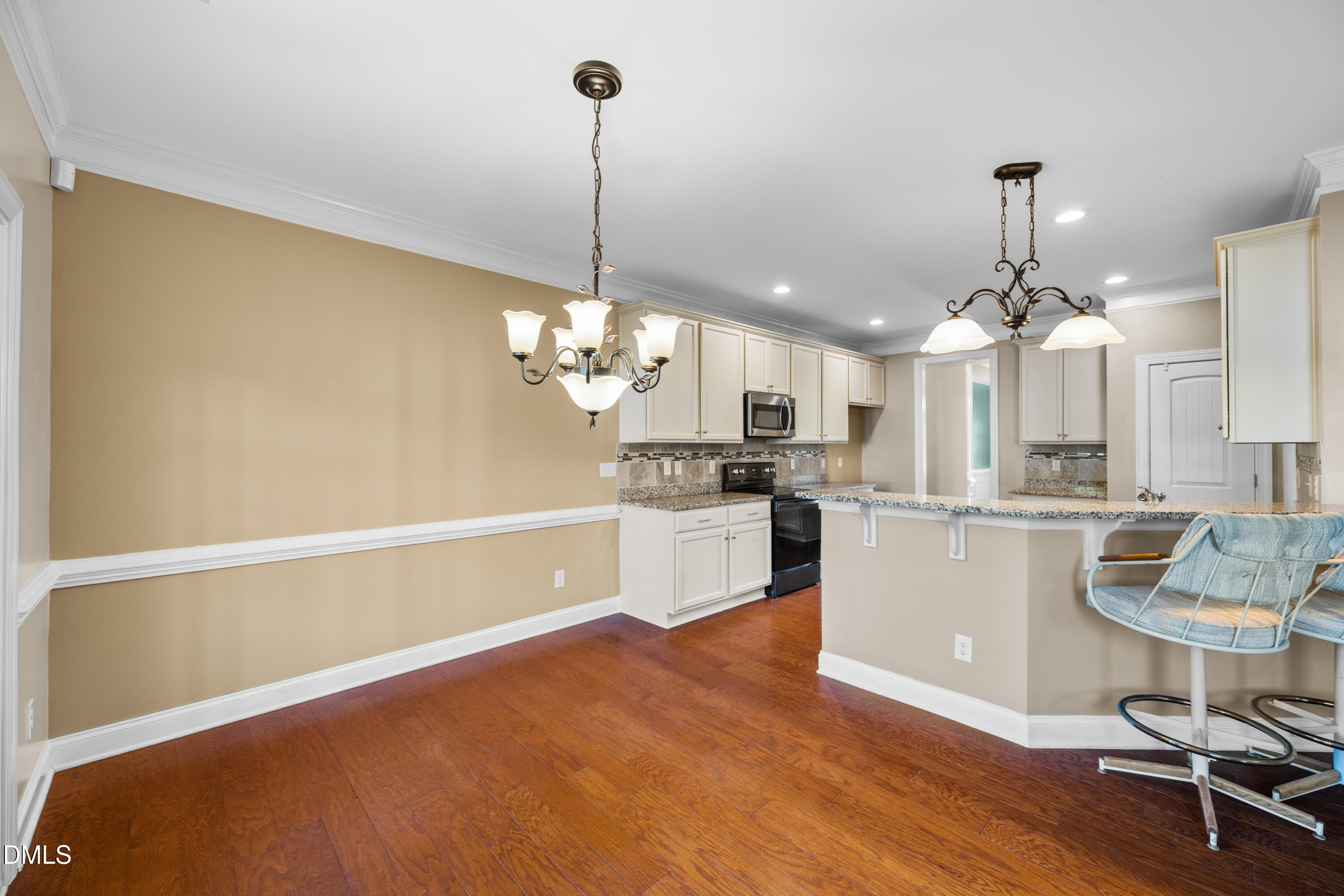 701 Spruce Meadows Lane Willow Spring, NC 27592 - Photo 11 of 54 a kitchen with kitchen island stainless steel appliances a dining table a sink a stove a chimney and a dining table