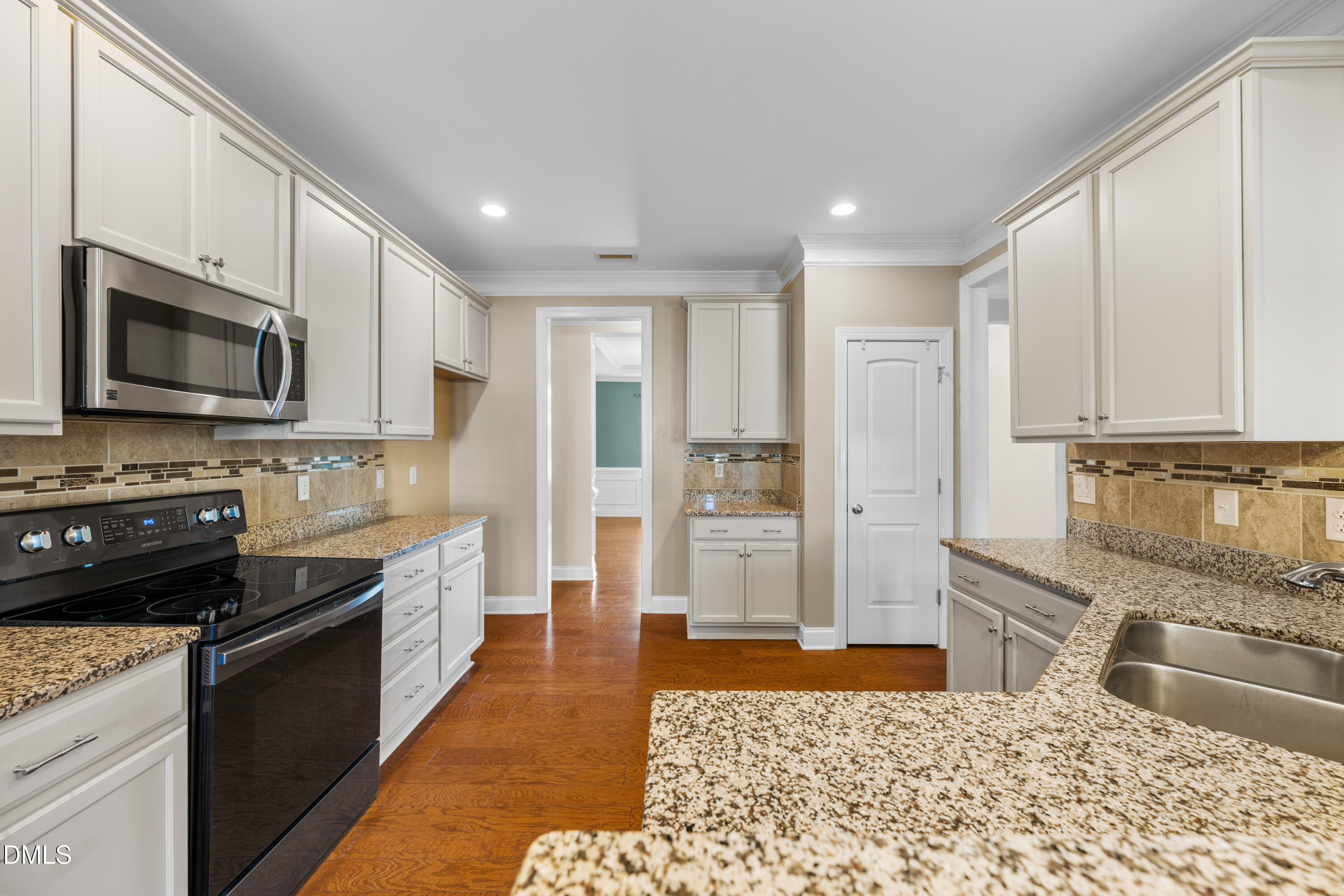 701 Spruce Meadows Lane Willow Spring, NC 27592 - Photo 12 of 54 a kitchen with stainless steel appliances granite countertop a refrigerator oven a sink dishwasher and white cabinets with wooden floor