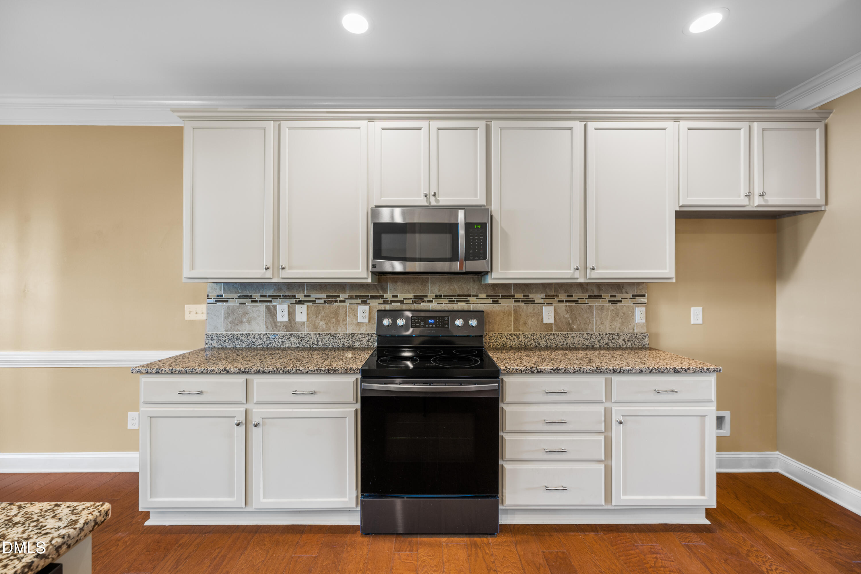 701 Spruce Meadows Lane Willow Spring, NC 27592 - Photo 15 of 54 a kitchen with granite countertop white cabinets and stainless steel appliances