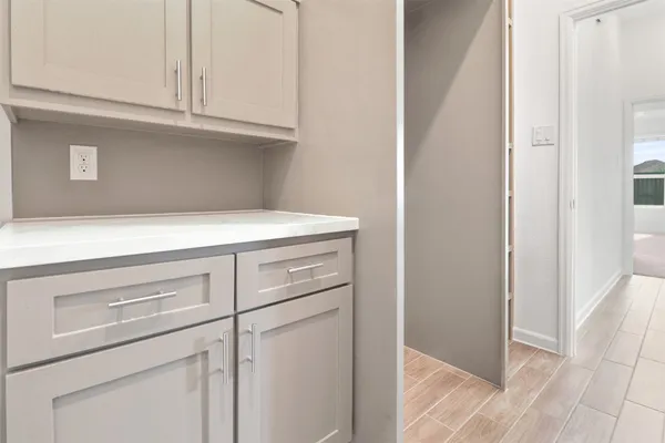a view of cabinets and utility room with closet
