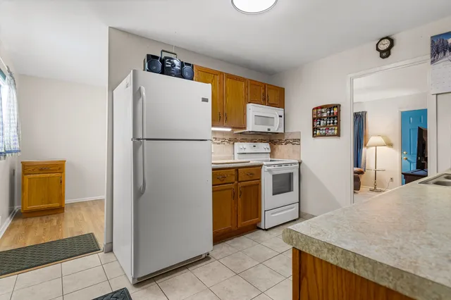 a kitchen with stainless steel appliances granite countertop a refrigerator a stove and a sink