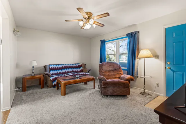 a living room with furniture and a ceiling fan
