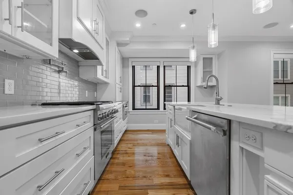 a large kitchen with stainless steel appliances lots of counter space and a sink