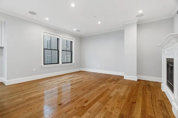 a view of empty room with wooden floor and fireplace