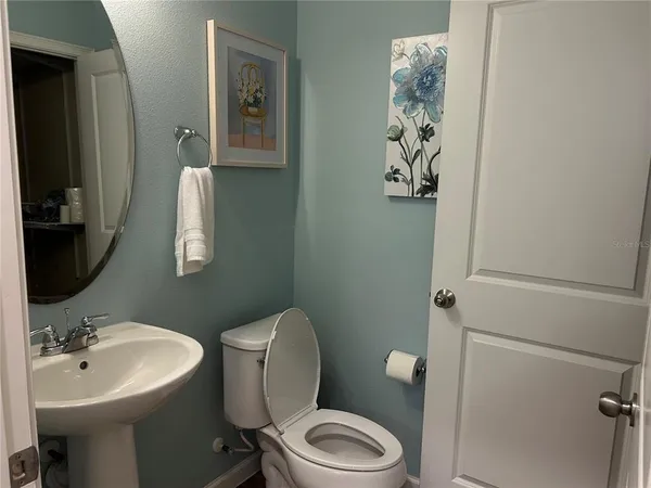 a bathroom with a toilet a sink and mirror