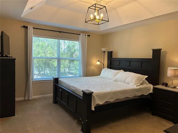 a bedroom with a bed and a chandelier