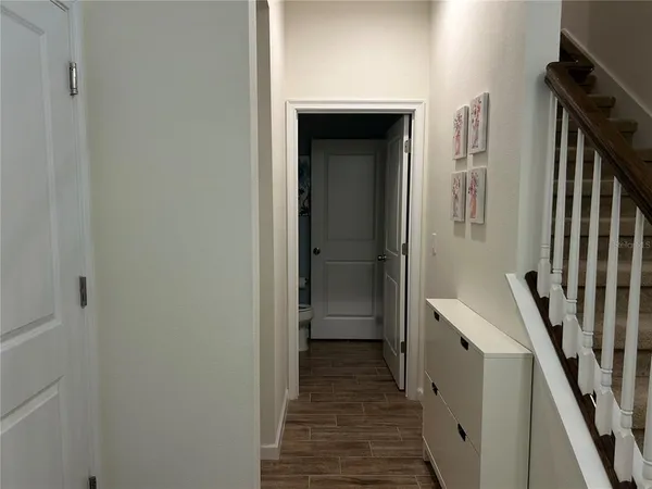 a view of a hallway with wooden floor and staircase
