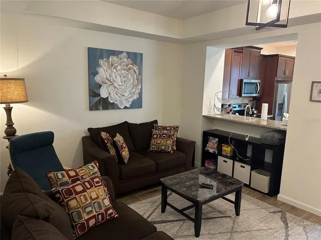 a living room with furniture and a painting on the wall