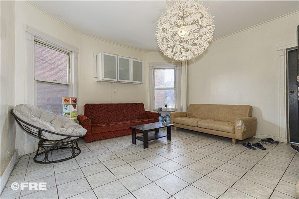 479 East 8th Street Brooklyn, NY 11218 - Photo 11 of 15 a living room with furniture and a chandelier