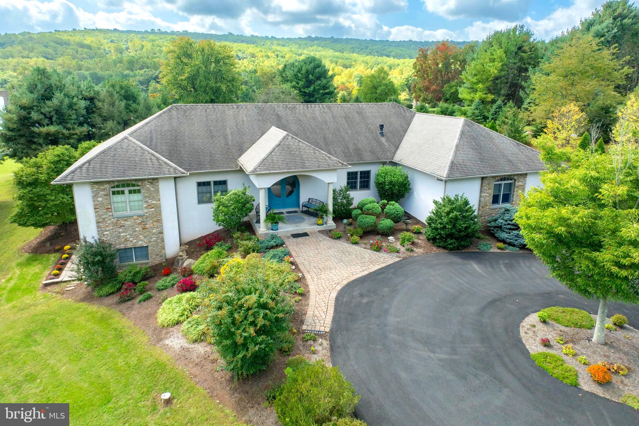 a aerial view of a house with table and chairs under an umbrella