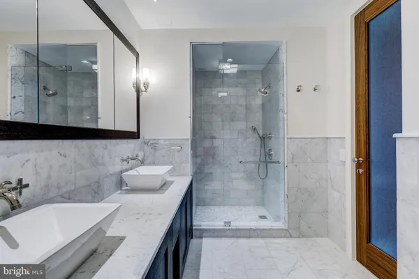 a bathroom with a bathtub shower sink and mirror