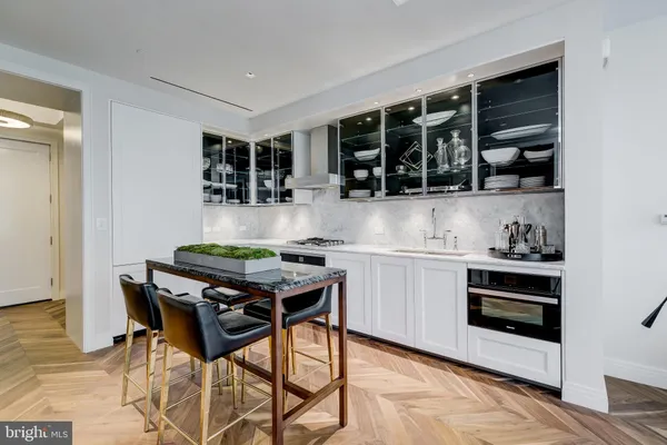 a kitchen with stainless steel appliances kitchen island granite countertop a stove and a view of living room