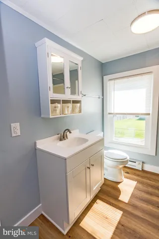 a bathroom with a sink toilet next to a window