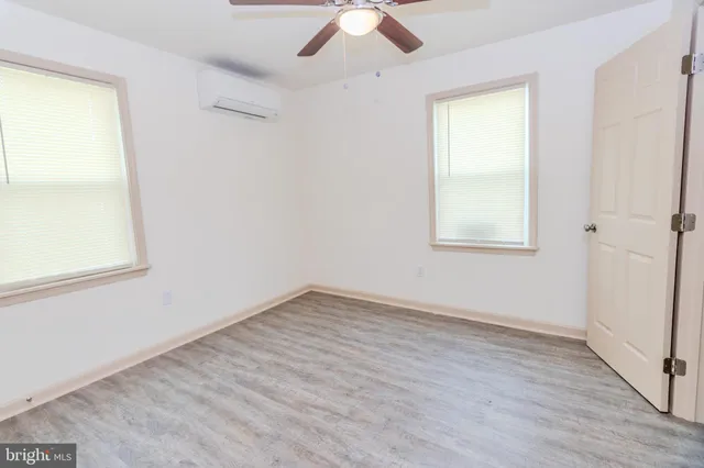 an empty room with a window and a ceiling fan
