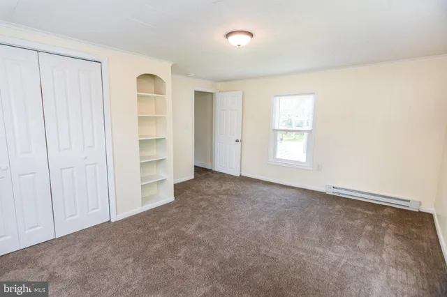 an empty room with closet and windows
