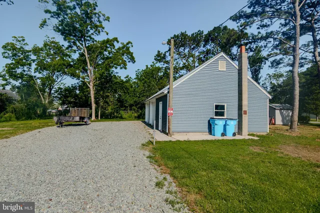 a view of a house with backyard and trees
