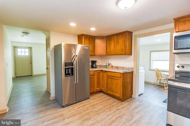 a kitchen with stainless steel appliances granite countertop a refrigerator and a stove top oven