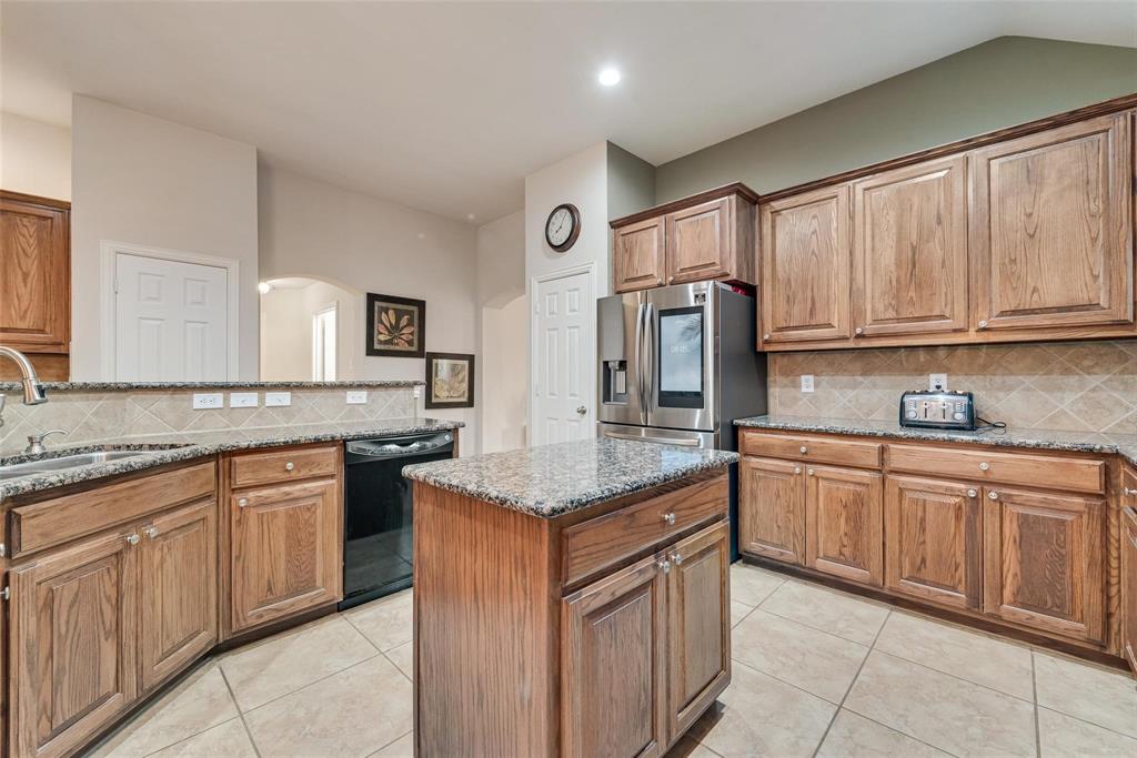 101 Cassandra Drive Forney, TX 75126 - Photo 6 of 21 a kitchen with stainless steel appliances granite countertop a sink and dishwasher a stove top oven with wooden floor