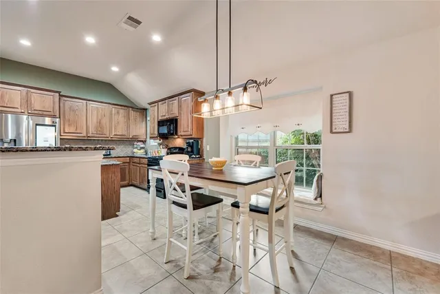 a kitchen with kitchen island granite countertop lots of counter top space and stainless steel appliances