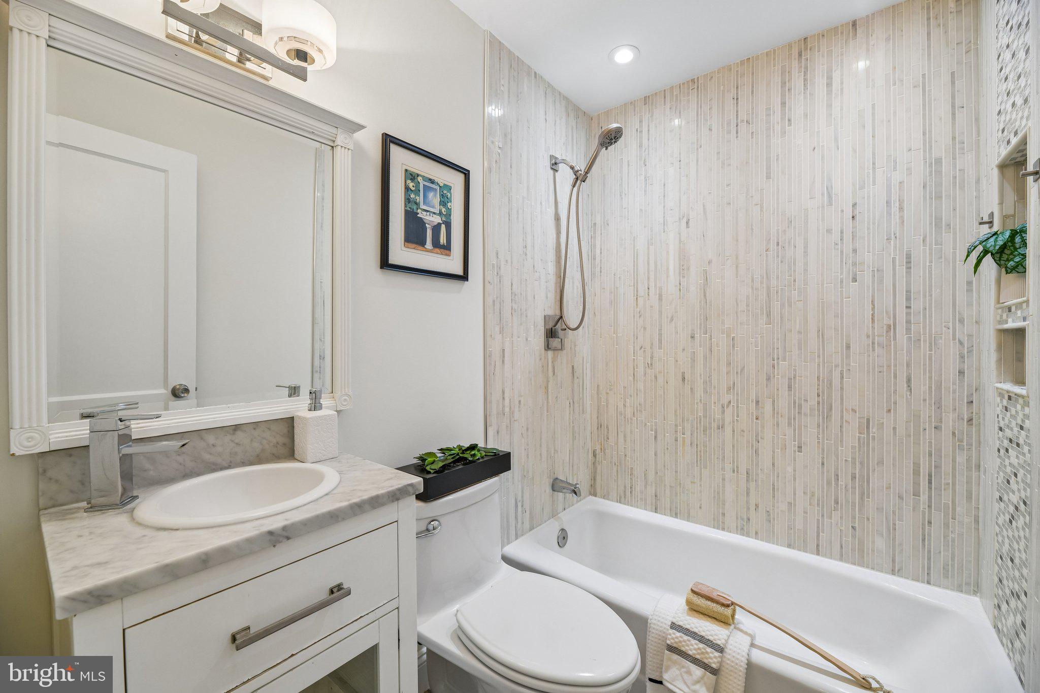 31 South Edison Street Arlington, VA 22204 - Photo 33 of 60 a bathroom with a granite countertop sink toilet a mirror a vanity and bathtub