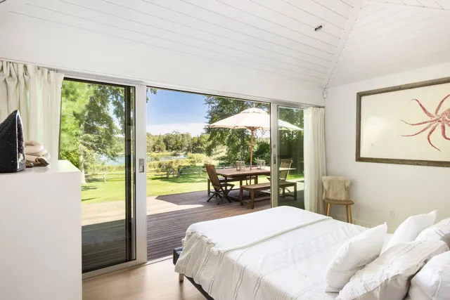 a bedroom with a bed and large windows