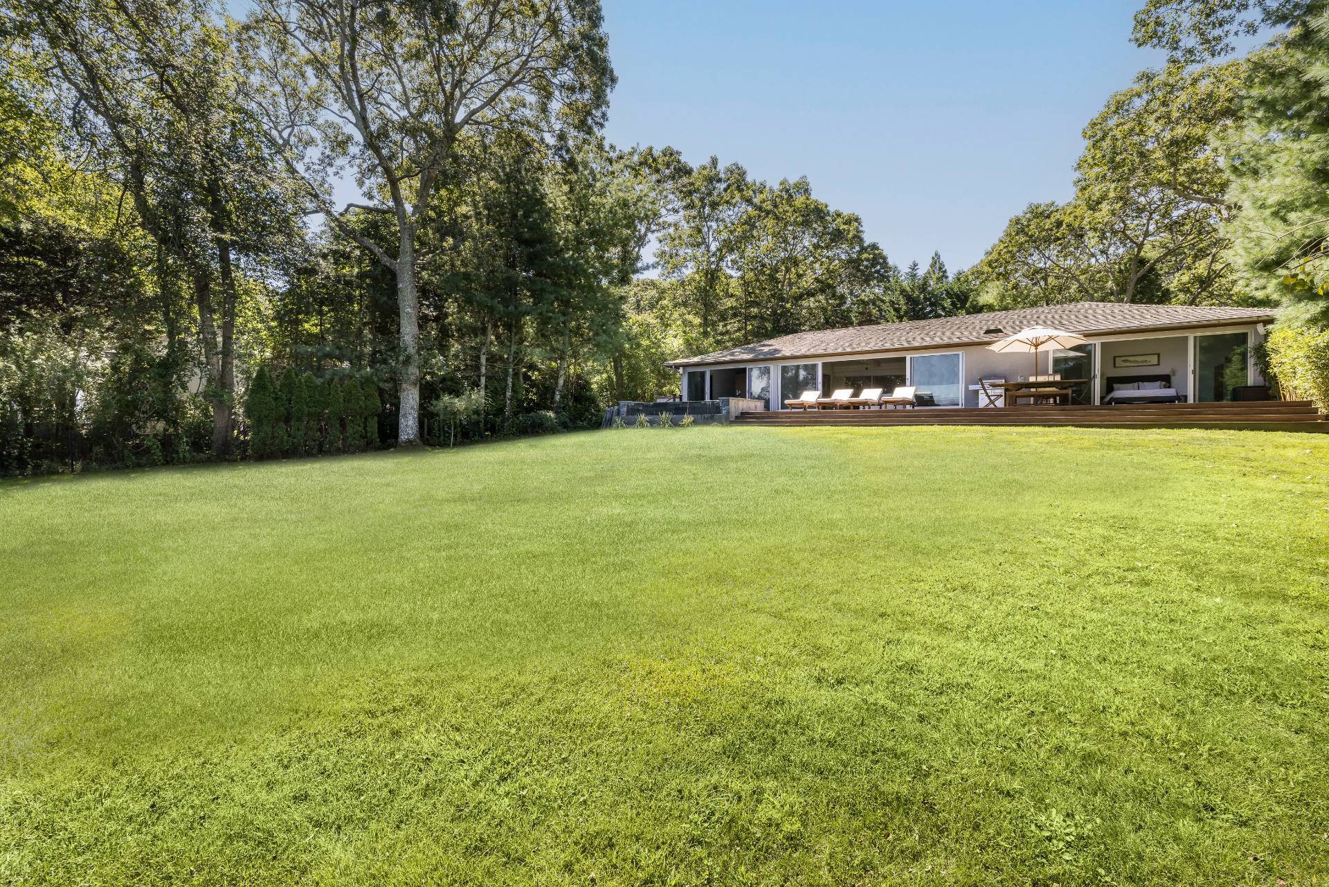 26 Oyster Shores Road East Hampton, NY 11937 - Photo 2 of 17 a front view of house with yard and trees