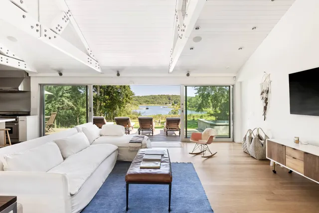 a living room with furniture large windows and flat screen tv