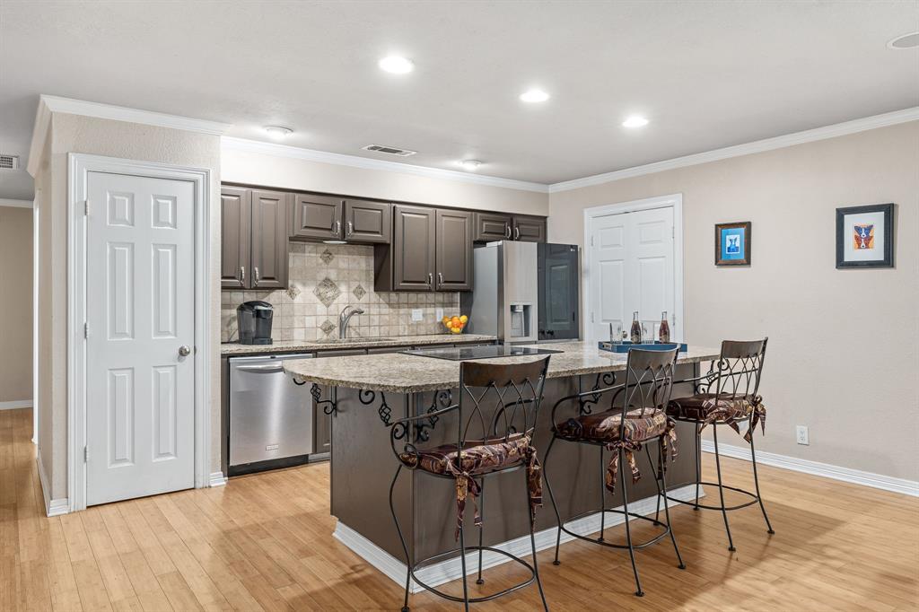a kitchen with stainless steel appliances kitchen island granite countertop a refrigerator and cabinets
