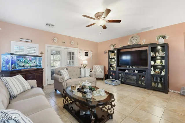 a living room with furniture a ceiling fan and a flat screen tv