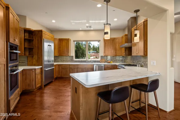 a large kitchen with kitchen island a large counter top space appliances and cabinets