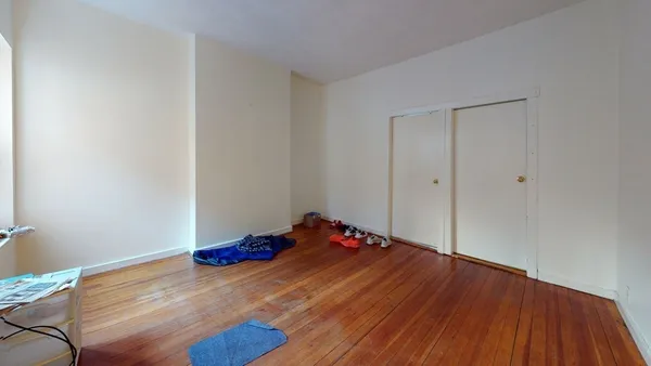 a room with a bed and wooden floor