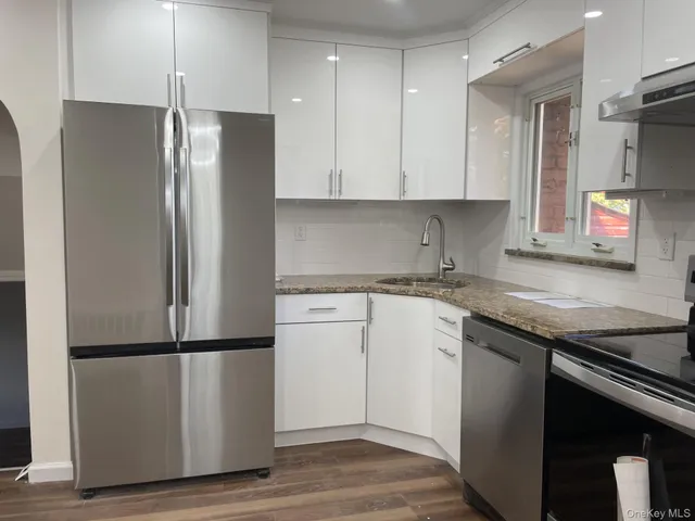 a kitchen with a refrigerator sink and cabinets