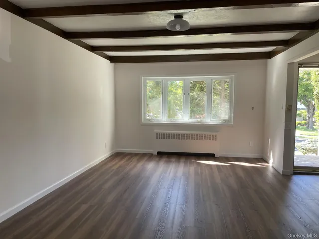 a view of a livingroom with wooden floor and a window