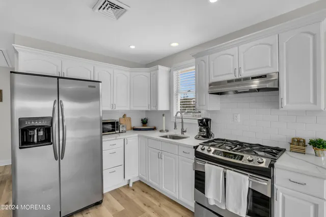 a kitchen with stainless steel appliances granite countertop a stove a refrigerator and a refrigerator