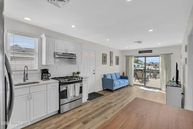a kitchen with stainless steel appliances granite countertop a sink stove and wooden cabinets