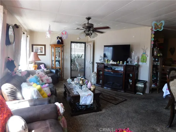 a living room with furniture a flat screen tv and a window