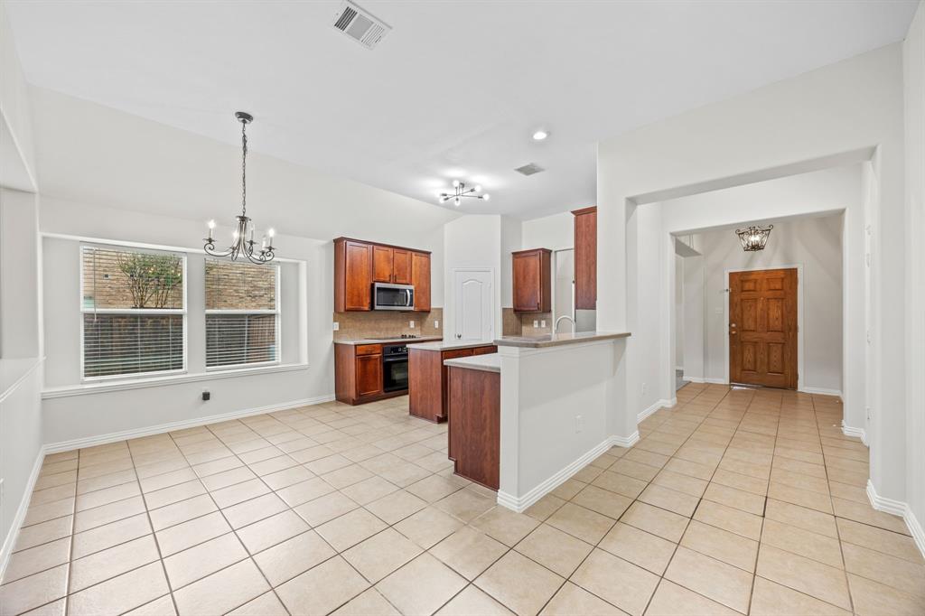 2804 Barco Grand Prairie, TX 75054 - Photo 4 of 25 a view of a kitchen with kitchen island granite countertop a refrigerator oven a sink and dishwasher with a dining table