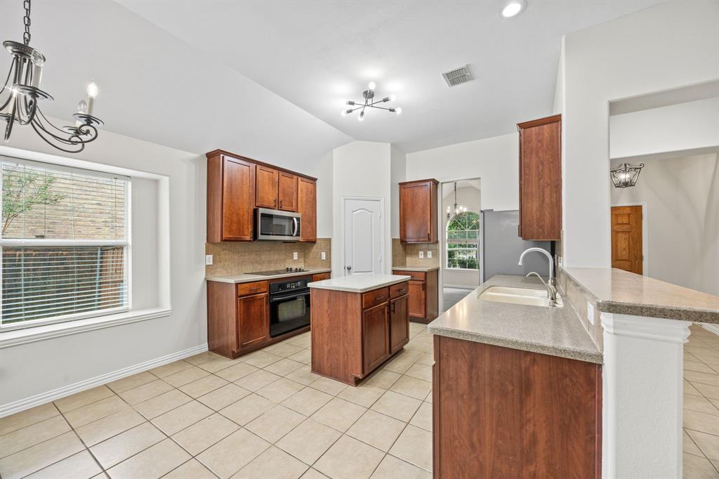 2804 Barco Grand Prairie, TX 75054 - Photo 6 of 25 a kitchen with stainless steel appliances granite countertop a sink stove and refrigerator