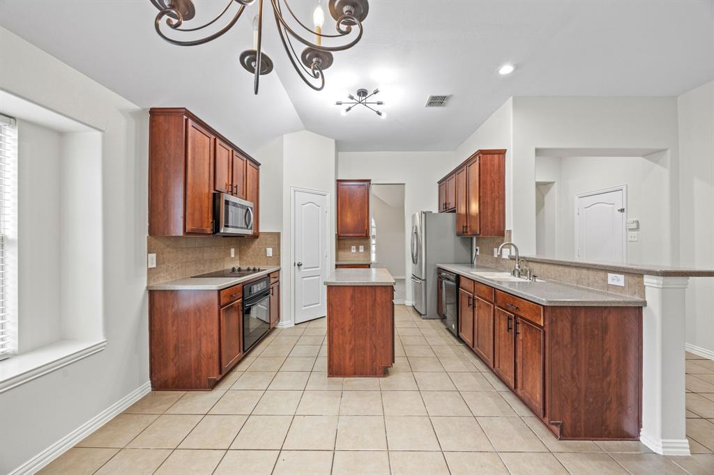 2804 Barco Grand Prairie, TX 75054 - Photo 7 of 25 a large kitchen with stainless steel appliances granite countertop a stove and cabinets