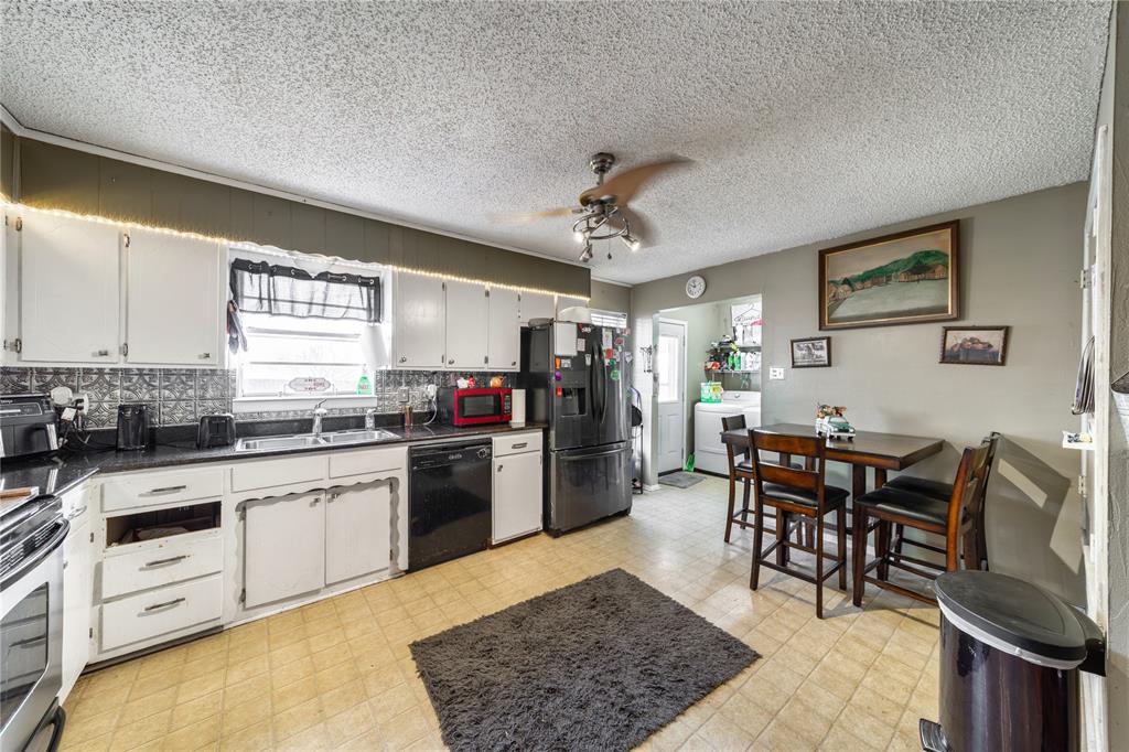 10 Carter Road Van Alstyne, TX 75495 - Photo 8 of 37 a kitchen with stainless steel appliances granite countertop a stove top oven a sink a dining table and chairs with wooden floor