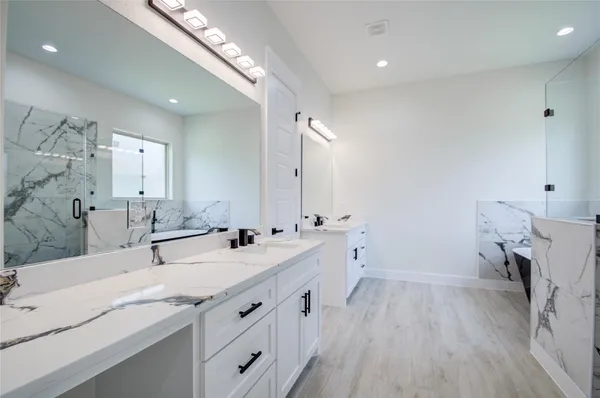 a spacious bathroom with double vanity and a mirror