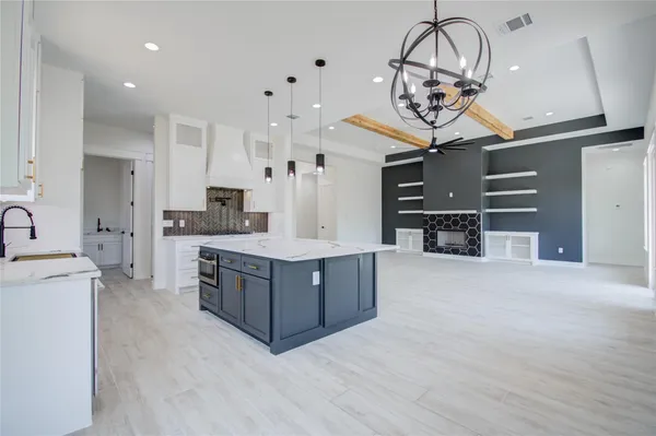 a large kitchen with stainless steel appliances a large counter top and cabinets
