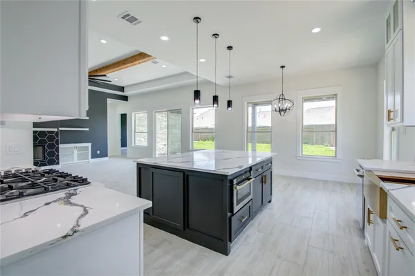 a kitchen with stainless steel appliances a stove and a wooden floor