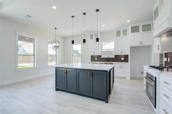 a large kitchen with stainless steel appliances granite countertop a stove a sink dishwasher and a large refrigerator