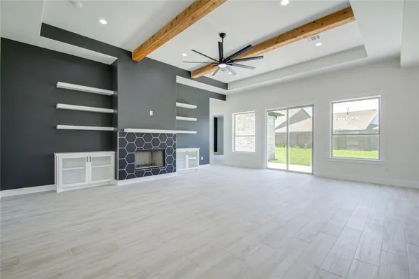 a view of an empty room with a fireplace and a window