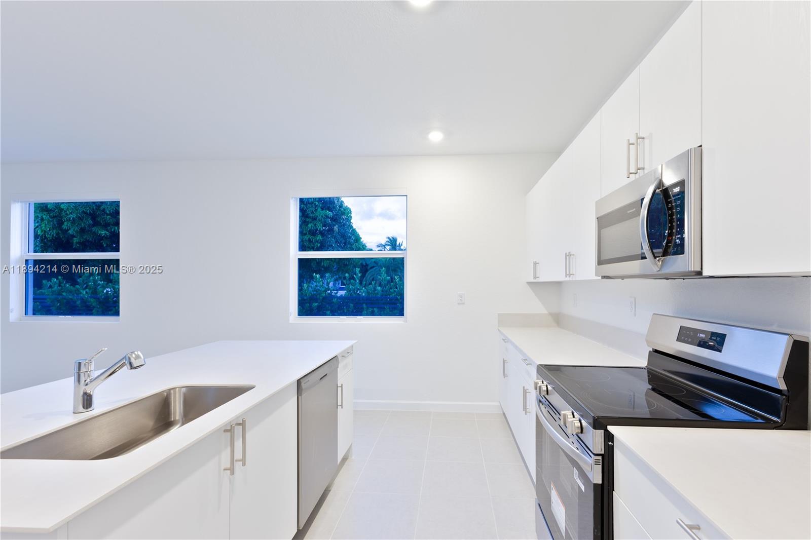 13203 Southwest 188th Terrace, Unit 13203 Miami, FL 33177 - Photo 24 of 49 a kitchen that has a sink and a stove in it